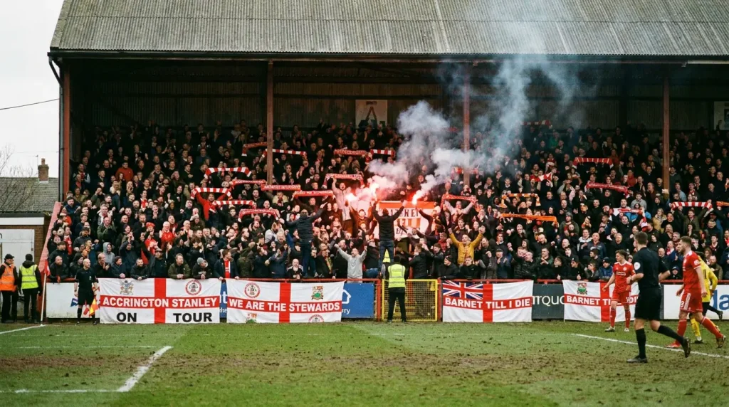 Packed lower-league terrace with passionate home supporters creating atmosphere